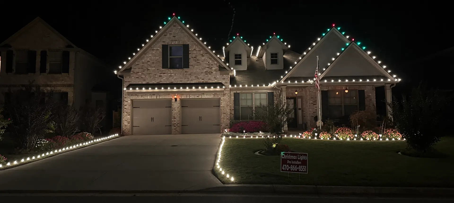 Brick Atlanta home glowing with roofline, pathway, and landscape Christmas lights by Be The Light GA