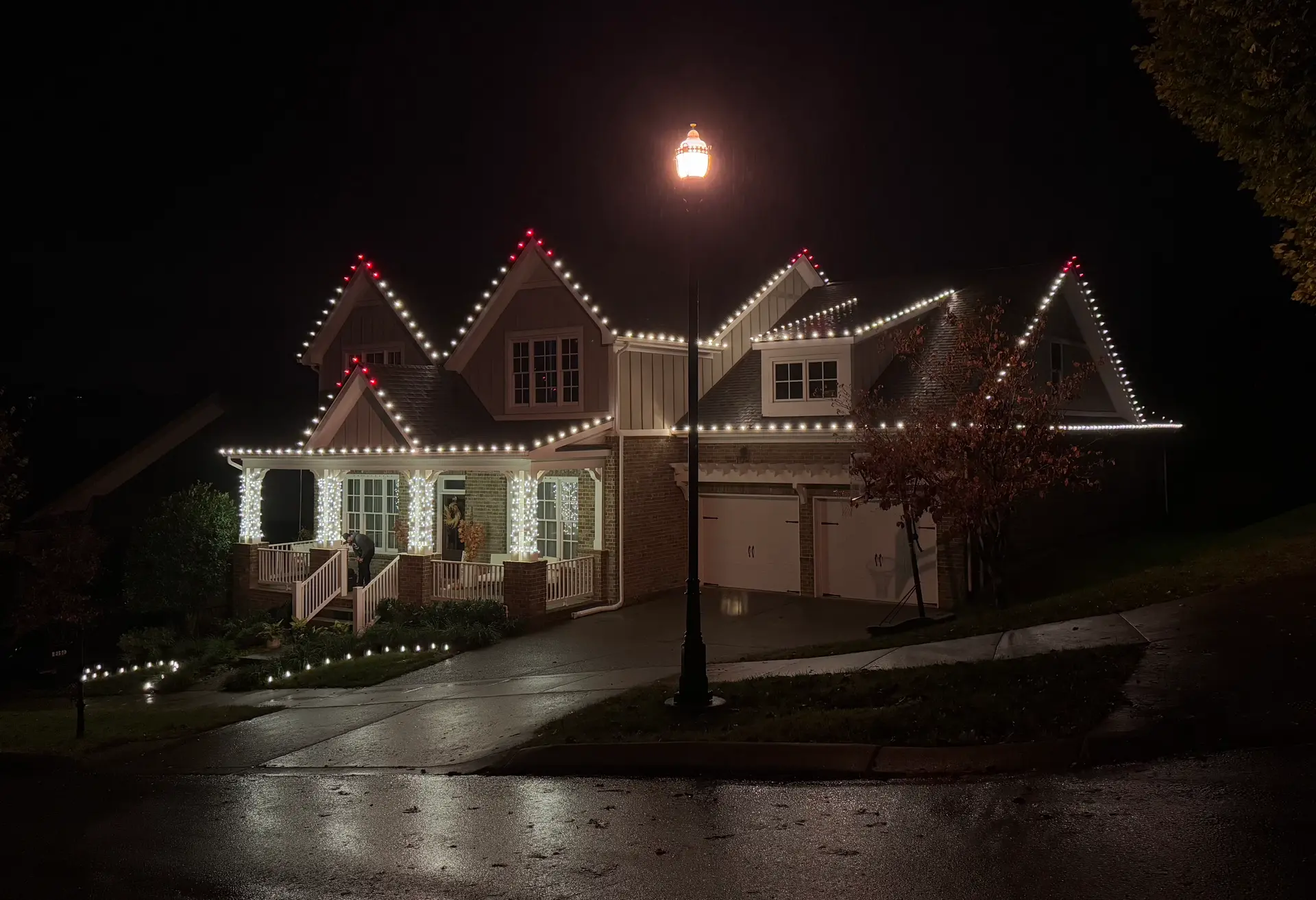 Craftsman home with white roofline lights and red-accented peaks by Be The Light GA