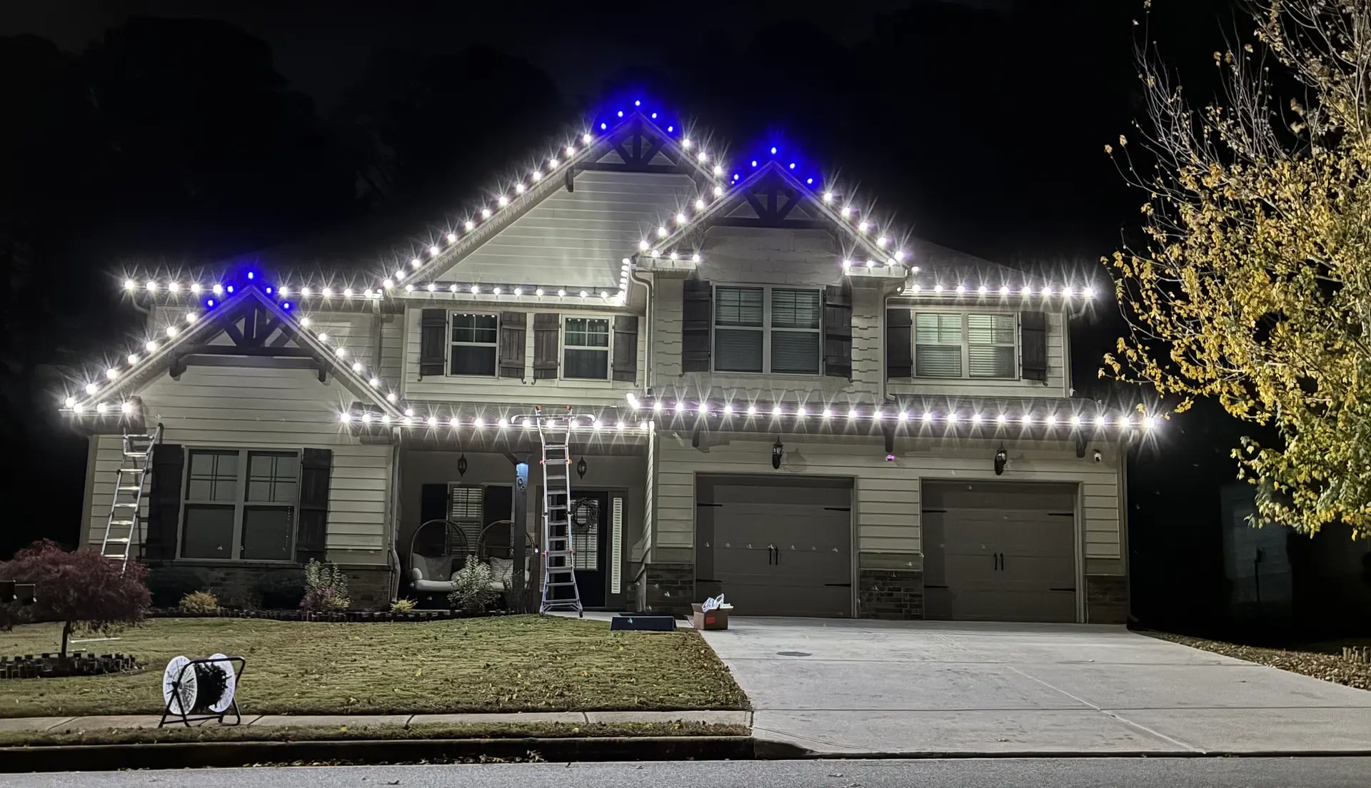 White roofline Christmas lights with blue-accented peaks by Be The Light GA